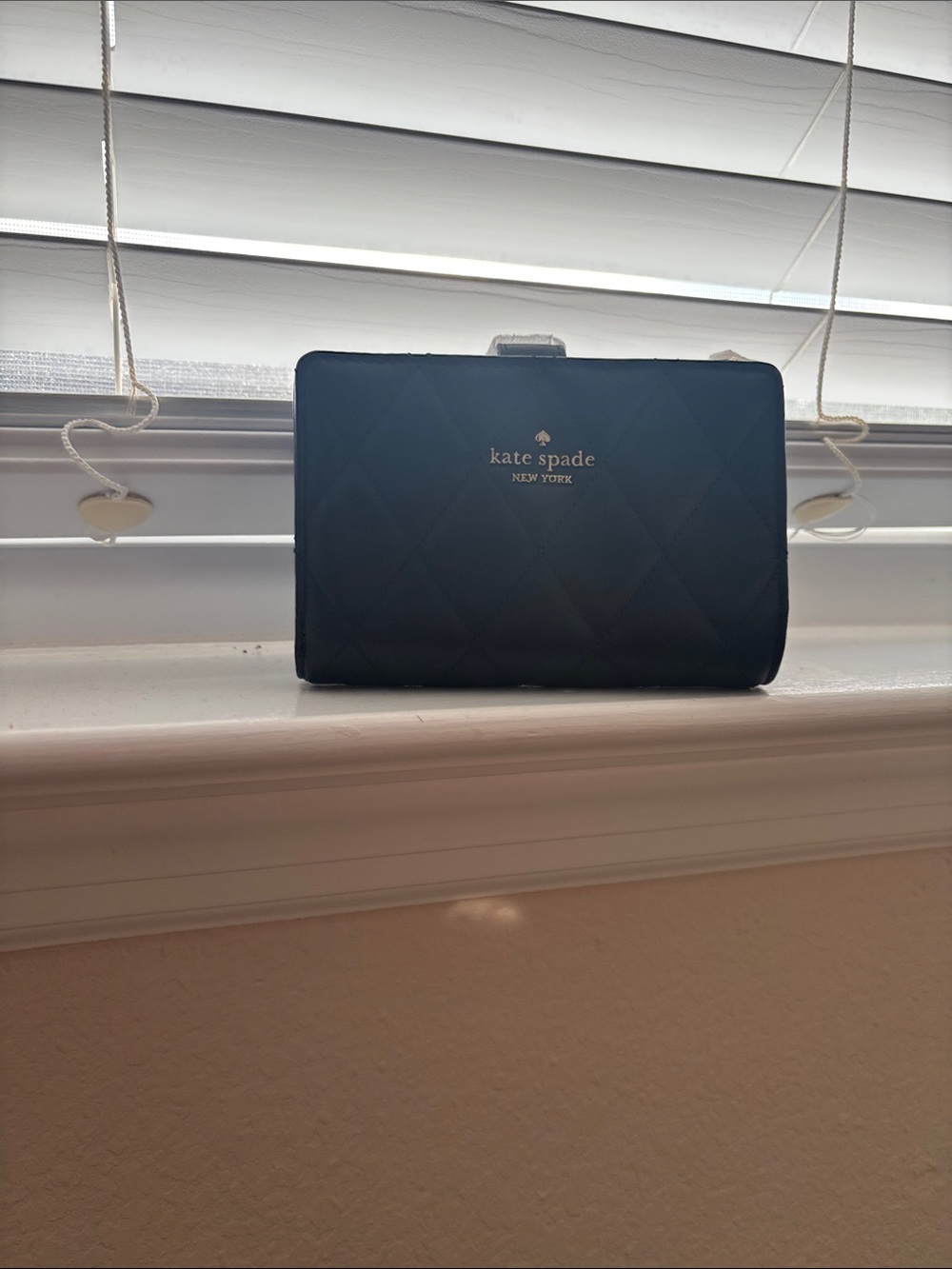 Kate Spade black quilted compact wallet with gold logo